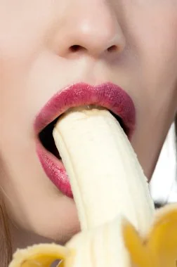 Image suggestive d'une femme mangeant une banane, évoquant les attentes en performance pour MANHOOD PLUS Gummies.